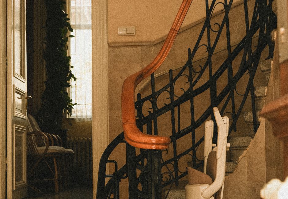 Monte-escalier replié au bas d'un escalier tournant dans une maison ancienne